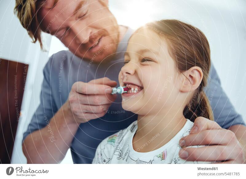 Vater putzt der Tochter im Badezimmer die Zähne Zahnbürste Zahnbürsten Papas Väter Vati Vatis Papis Töchter Zähne putzen Zaehne putzen Eltern Familie Familien