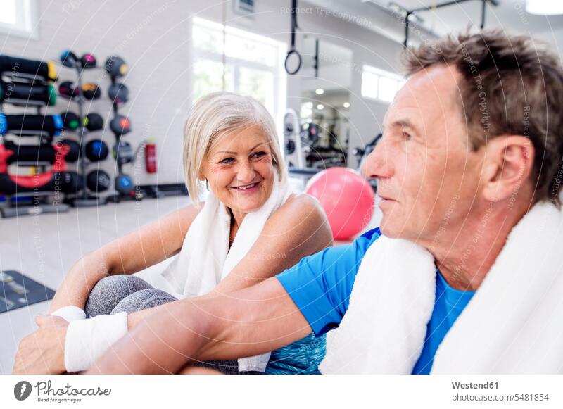Lächelnde reife Frau und älterer Mann machen eine Pause im Fitnessstudio Senioren alte lächeln Fitnessclubs Fitnessstudios Turnhalle Paar Pärchen Paare