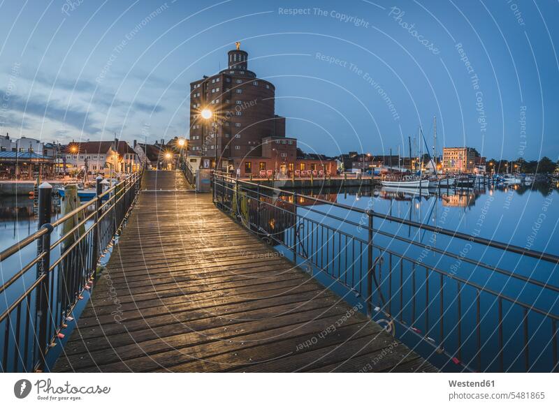 Deutschland, Eckernfoerde, Blick auf altes Silo und Hafen in der Abenddaemmerung beleuchtet Beleuchtung Architektur Baukunst Schiffsanlegestelle Lichtstrahl