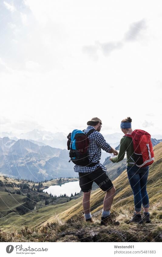 Deutschland, Bayern, Oberstdorf, zwei Wanderer mit Karte in alpiner Landschaft Karten Paar Pärchen Paare Partnerschaft wandern Wanderung stehen stehend steht