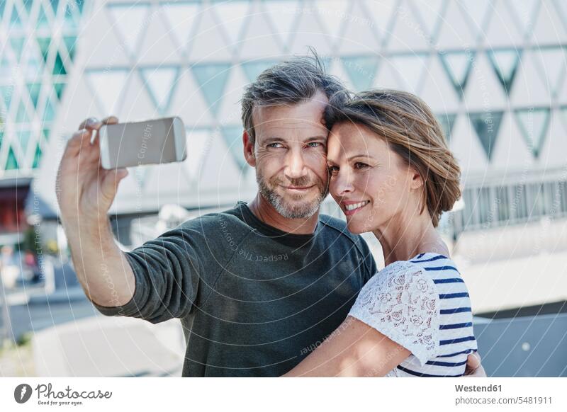Glückliches reifes Paar macht ein Selfie im Freien Liebe lieben lächeln Pärchen Paare Partnerschaft positiv Emotion Gefühl Empfindung Emotionen Gefühle fühlen