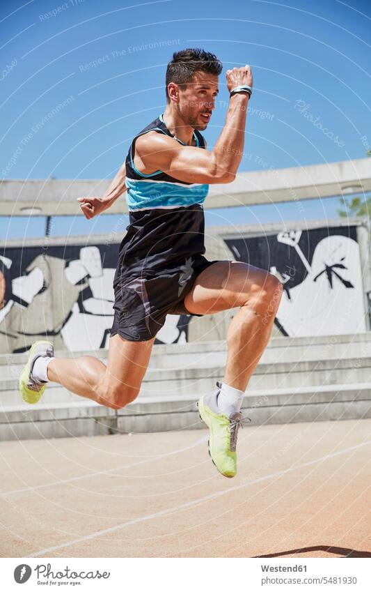 Fähiger Mann trainiert im Freien Sportler trainieren springen hüpfen Sprung Spruenge Sprünge laufen rennen Fitness fit Gesundheit gesund Training zielstrebig