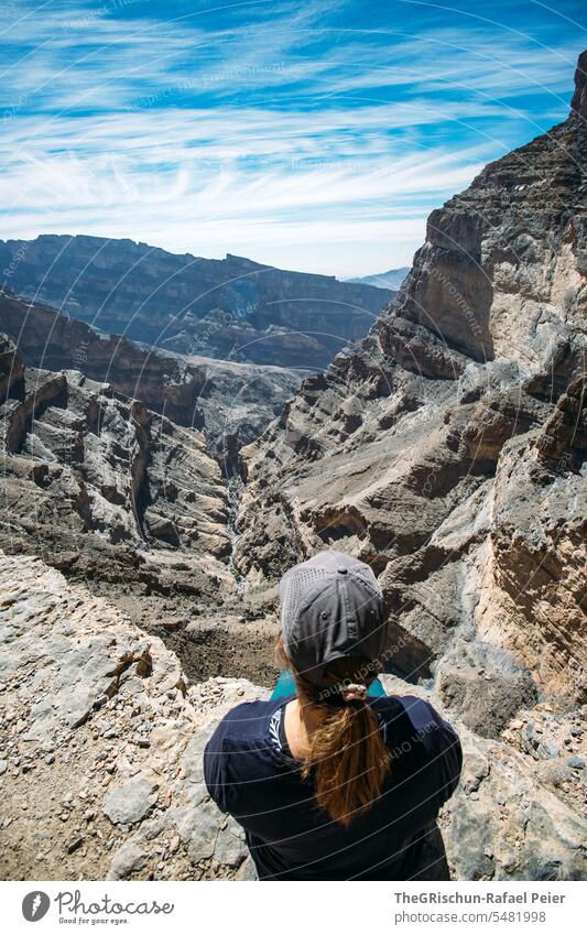 Frau sitzt am Rande des Canyons und geniess die Weite Oman Himmel Natur Farbfoto Bergpanorama Aussicht Panorama (Aussicht) trocken heiß reisen Tourismus