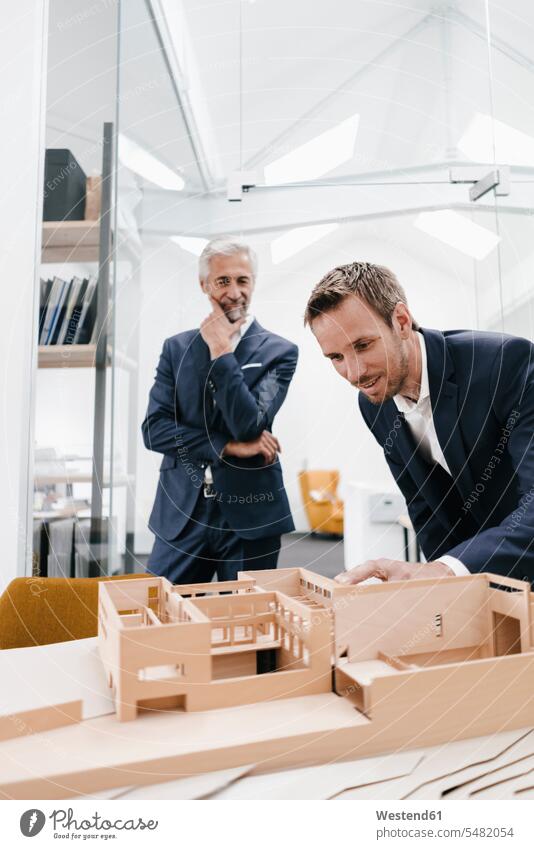 Zwei Geschäftsleute untersuchen Architekturmodell im Büro Modell Modelle Office Büros Architekten lächeln prüfen Kontrolle Untersuchung kontrollieren pruefen