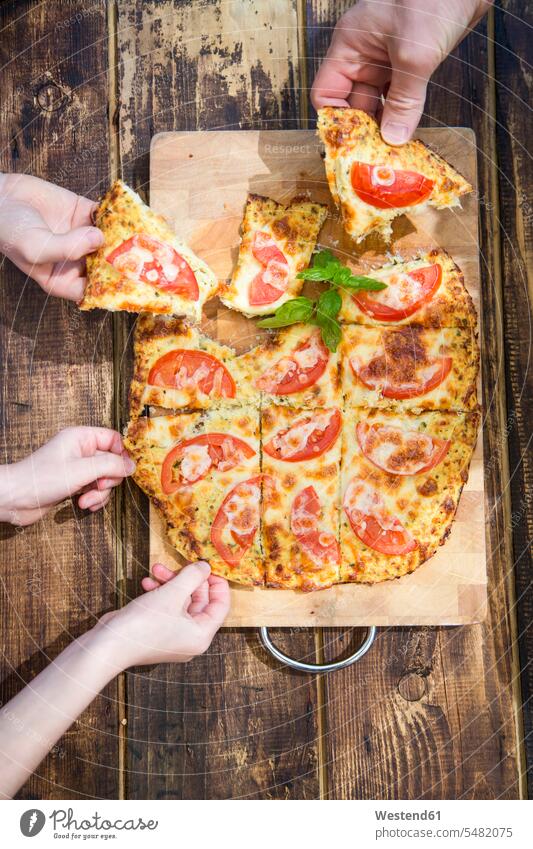 Handauflegen von hausgemachten Pizzastücken mit Blumenkohl und Tomaten Pizzen Essen Food Food and Drink Lebensmittel Essen und Trinken Nahrungsmittel Hände