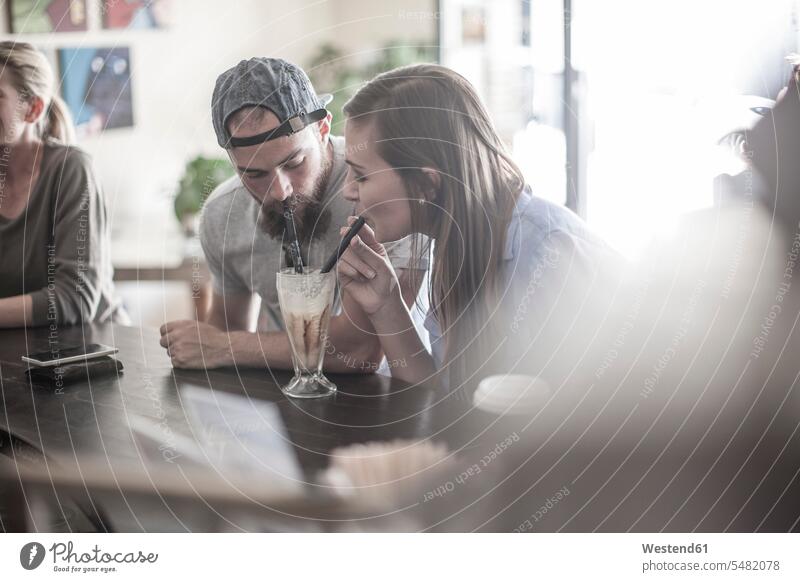 Mann und Frau teilen sich einen Milchshake im Café Europäer Kaukasier Europäisch kaukasisch trinken Milchshakes Menschen zufällige Personen zwei Personen 2