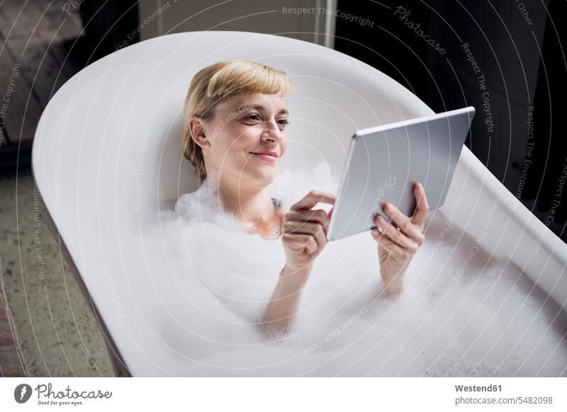 Porträt einer entspannten Frau, die während der Tabletteneinnahme ein Schaumbad nimmt weiblich Frauen Badewanne Badewannen Tablet Computer Tablet-PC Tablet PC