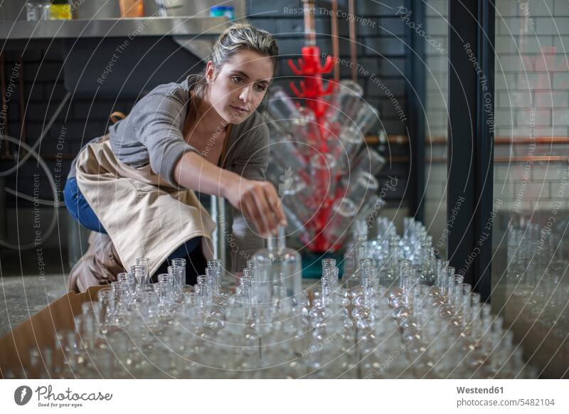 Junge Frau sortiert Glasflaschen weiblich Frauen Flasche Flaschen Erwachsener erwachsen Mensch Menschen Leute People Personen arbeiten Arbeit Destillerie