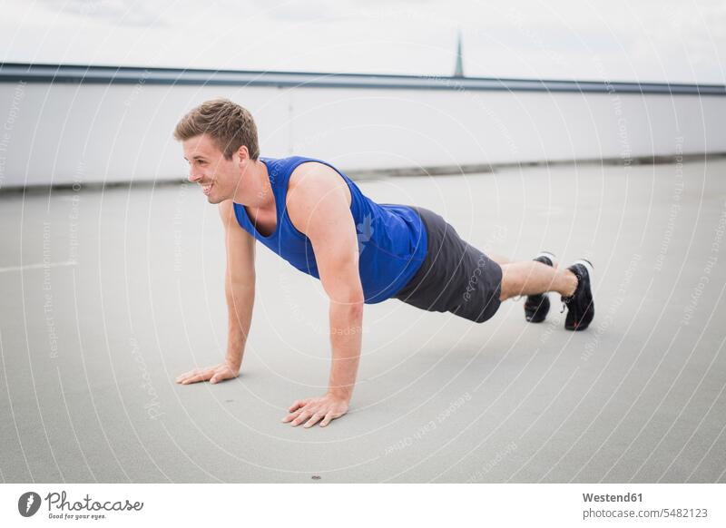 Mann macht Liegestützen im Freien sportlich Männer männlich trainieren Training Plank Schiefe Ebene Push-Up Pushups Push-Ups Workout Sport Erwachsener erwachsen
