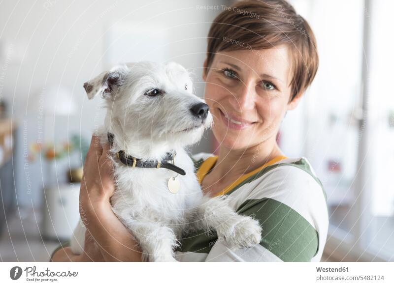Porträt einer lächelnden Frau mit Hund auf dem Arm Portrait Porträts Portraits Hunde weiblich Frauen Haustier Haustiere Tier Tierwelt Tiere Erwachsener
