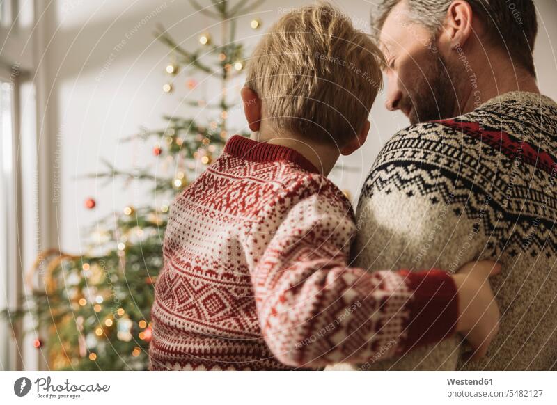Vater und kleiner Sohn schauen auf den Weihnachtsbaum Europäer Kaukasier Europäisch kaukasisch Geborgenheit geborgen behütet Sicherheit behüten Liebe lieben