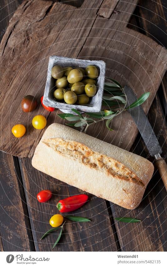 Ciabattabrot mit grünen Oliven in Schale, Tomaten und Minipaprika auf Holz Niemand Frische frisch Gesunde Ernährung Ernaehrung Gesunde Ernaehrung Gesundheit