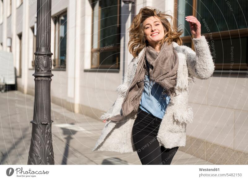Porträt einer lachenden Frau, die auf dem Bürgersteig läuft weiblich Frauen laufen rennen Portrait Porträts Portraits Erwachsener erwachsen Mensch Menschen