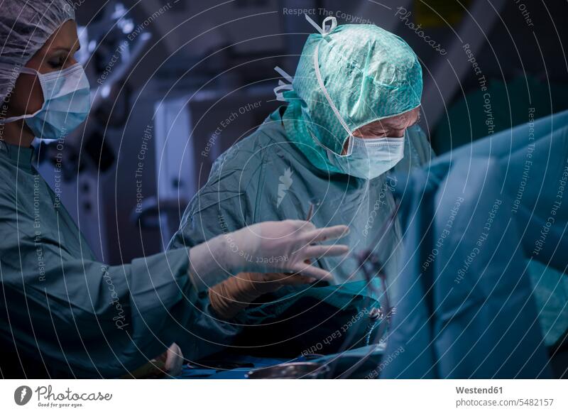Neurochirurg mit Krankenschwester schließt Operationswunde OP Operationen operieren Chirurgie Arzt Doktoren Ärzte Schwestern Krankenpflegerin Krankenschwestern
