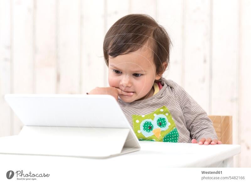 Porträt eines nachdenklichen kleinen Mädchens, das auf ein digitales Tablett schaut weiblich Tablet Computer Tablet-PC Tablet PC iPad Tablet-Computer Kind