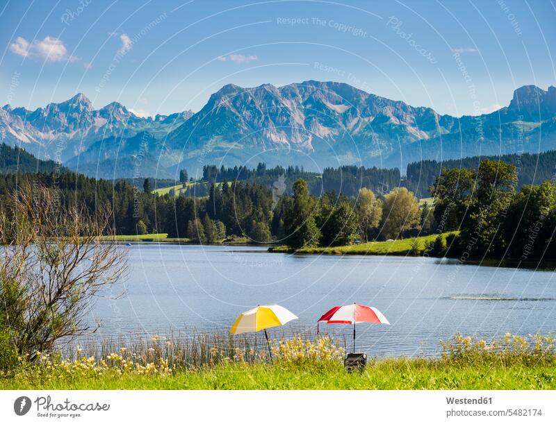 Deutschland, Bayern, Allgäu, Schwaltenweiher See mit Brentenjoch Sonnenschirm Sonnenschirme Natur Badesee Weiher Schönheit der Natur Schoenheit der Natur