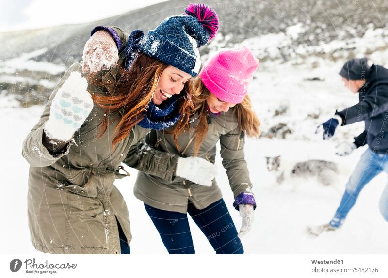 Freunde bei einer Schneeballschlacht im Schnee Winter winterlich Winterzeit spielen lachen Schneeballschlachten Freundschaft Kameradschaft positiv Emotion
