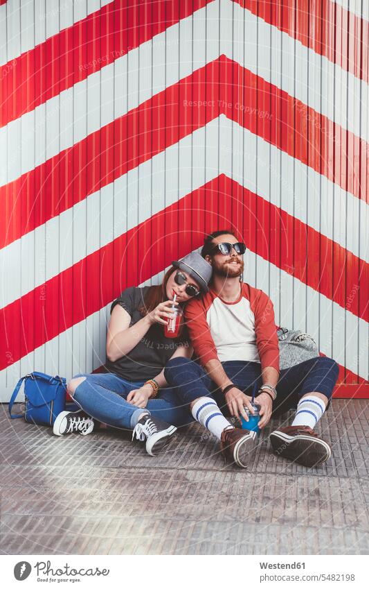 Junges Paar entspannt sich auf der Straße Zufriedenheit zufrieden Lifestyle Lifestyles trinken Entspannung Entspannen relaxen entspannen rotweiß rot-weiss