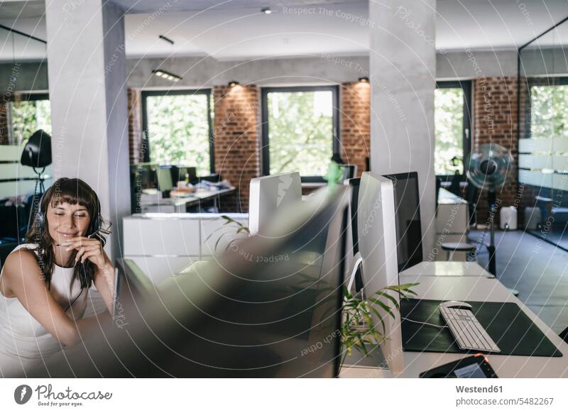 Geschäftsfrau, die im Büro arbeitet, am Telefon spricht Büroangestellte Schreibtisch Arbeitstisch Schreibtische sitzen sitzend sitzt arbeiten telefonieren