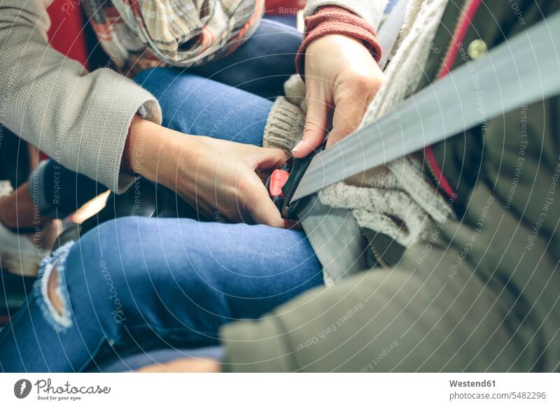 Nahaufnahme einer Frau, die den Sicherheitsgurt eines im Auto sitzenden Mädchens anlegt Mutter Mami Mutti Mütter Mama Sicherheitsgurte Anschnallgurt
