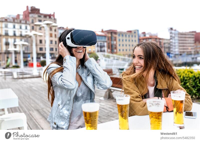 Zwei junge Frauen haben Spaß mit VR-Brillen in der Stadt Virtual Reality Brille Virtual-Reality-Brille Virtual Reality-Brille VR Brille Spass Späße spassig