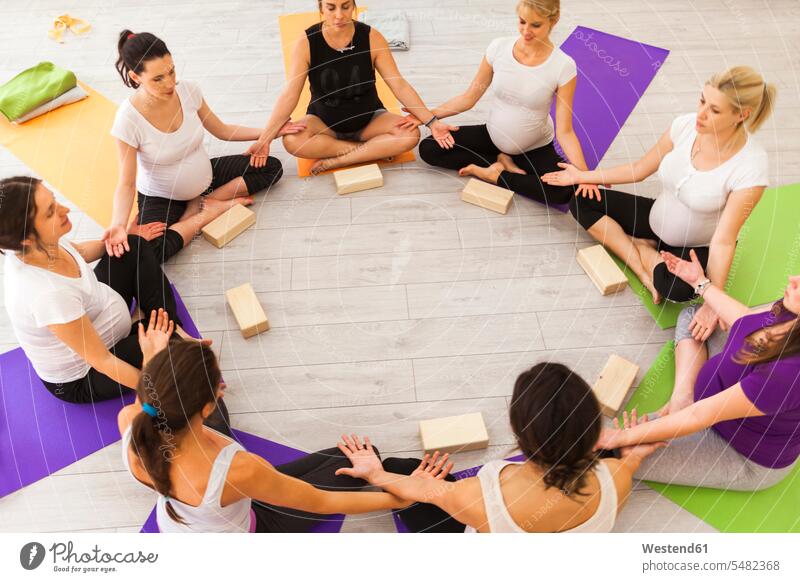 Pränataler Yoga-Unterricht im Kreis sitzend schwanger Schwangere schwangere Frau Gruppe Gruppe von Menschen Menschengruppe sitzt Kurs weiblich Frauen