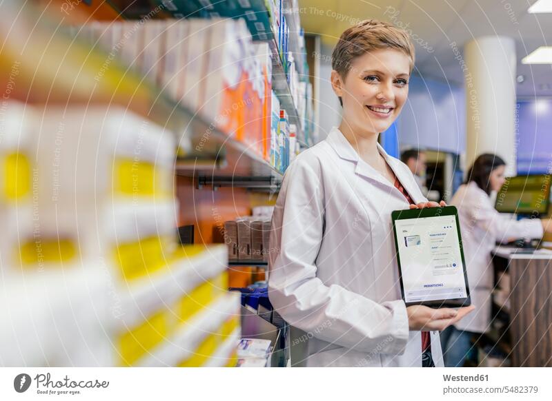 Porträt eines lächelnden Apothekers in der Apotheke, der eine Tablette mit digitaler Bestellung hält Tablet Computer Tablet-PC Tablet PC iPad Tablet-Computer