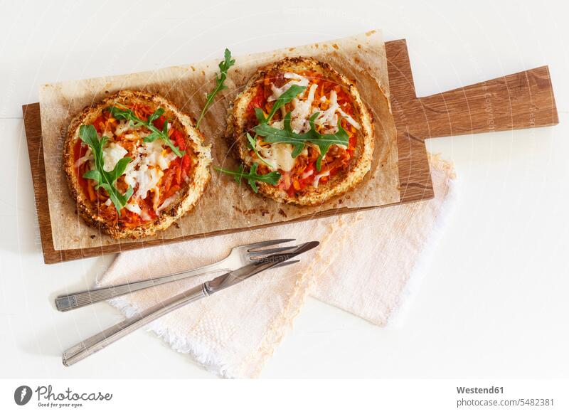 Zwei hausgemachte glutenfreie Mini-Pizzas mit Blumenkohl, Kürbis und Rucola auf Holzbrett Food and Drink Lebensmittel Essen und Trinken Nahrungsmittel