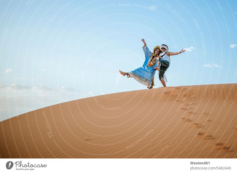 Berbermann und -frau beim Touristengruß in der Wüste Führer Touristin Marokko Reise Travel Wüsten Spaß Spass Späße spassig Spässe spaßig Tourismus Nordafrika