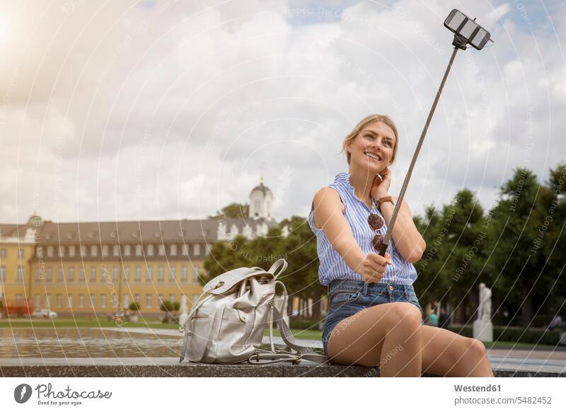 Deutschland, Karlsruhe, Tourist macht Selfie mit Selfie-Stick Selfies Touristin Selfiestick Frau weiblich Frauen Touristen Tourismus Erwachsener erwachsen