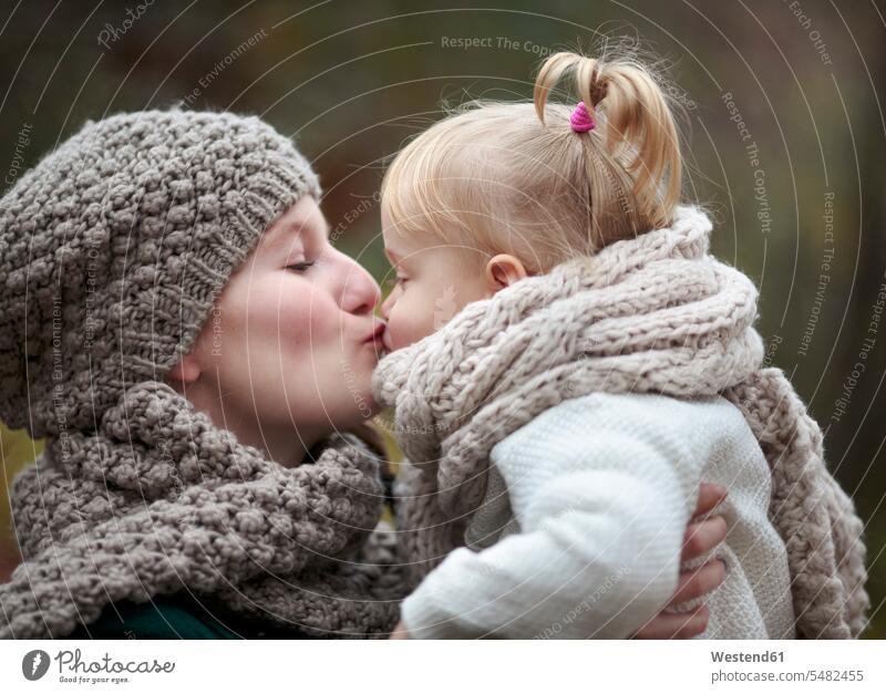 Junge Frau küsst ihre kleine Tochter im Herbst Europäer Kaukasier Europäisch kaukasisch Kindheit Brustbild Oberkörper Europäerin Europäerinnen Kaukasierin