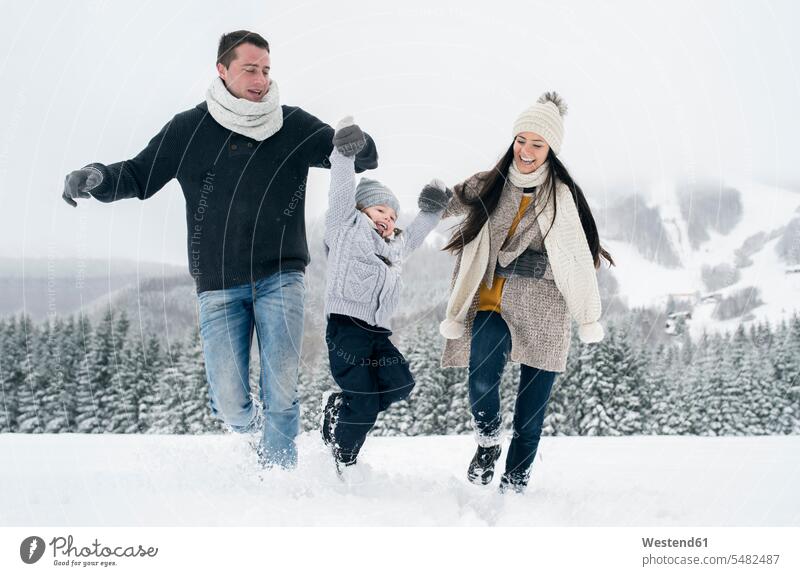 Glückliche Familie in Winterlandschaft winterlich Winterzeit Familien Spaß Spass Späße spassig Spässe spaßig glücklich glücklich sein glücklichsein Mensch