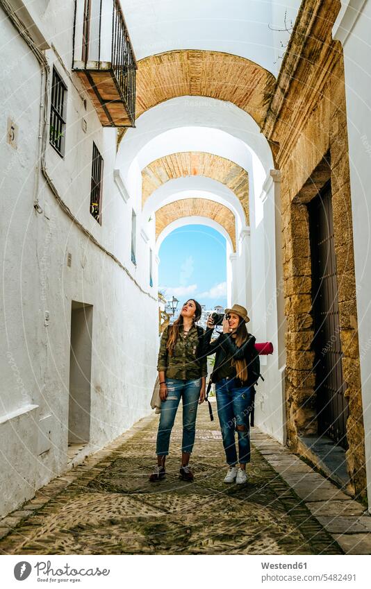 Spanien, Andalusien, Vejer de la Frontera, zwei junge Frauen beim Fotografieren in der Gasse El Callejon de las Monjas Freundinnen Gassen fotografieren Freunde
