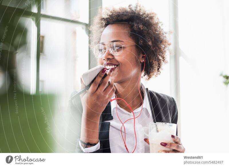 Lächelnde junge Frau benutzt Mobiltelefon in einem Cafe lächeln Handy Handies Handys Mobiltelefone Kaffeehaus Bistro Cafes Café Cafés Kaffeehäuser weiblich