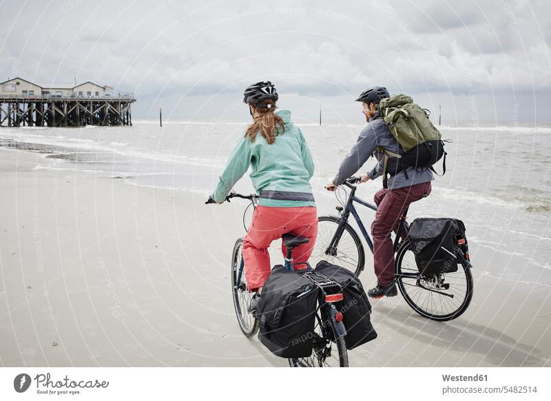 Deutschland, Schleswig-Holstein, St. Peter-Ording, Ehepaar beim Fahrradfahren am Strand Bikes Fahrräder Räder Rad Paar Pärchen Paare Partnerschaft Beach