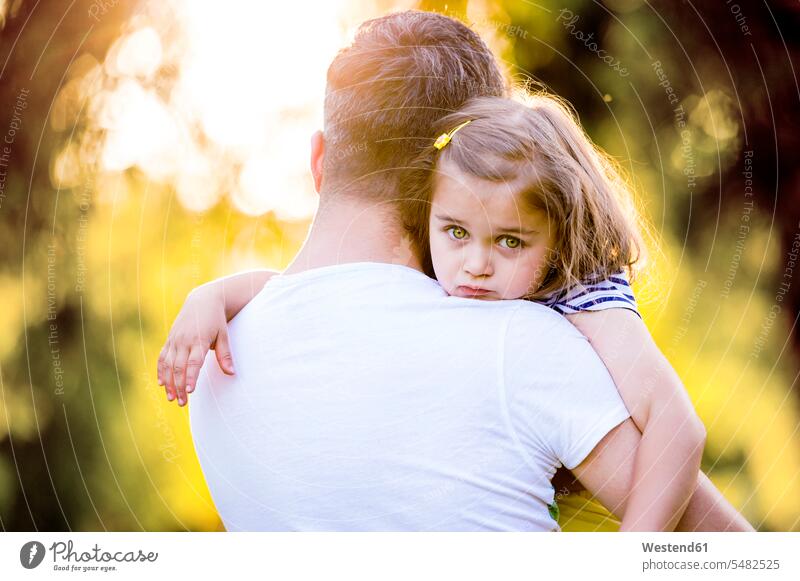 Porträt eines traurigen kleinen Mädchens auf dem Arm des Vaters Papas Väter Vati Vatis Papis Tochter Töchter Eltern Familie Familien Mensch Menschen Leute