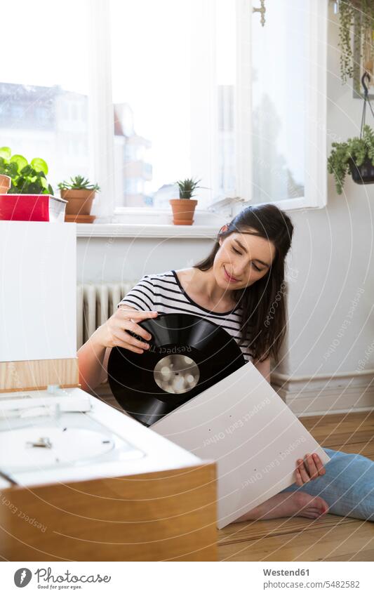 Lächelnder Mann zu Hause mit Rekord Schallplatte Vinyl Schallplatten Frau weiblich Frauen lächeln analog Medien Medium Erwachsener erwachsen Mensch Menschen