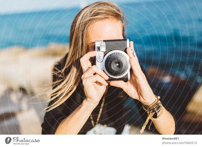 Junge Frau fotografiert mit altmodischer Kamera an der Strandpromenade Fotoapparat Fotokamera weiblich Frauen fotografieren Erwachsener erwachsen Mensch