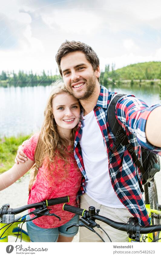 Junges Paar macht Selfies auf einer Fahrradtour Ausflug Ausflüge Kurzurlaub Ausfluege glücklich Glück glücklich sein glücklichsein lächeln Radfahrerin