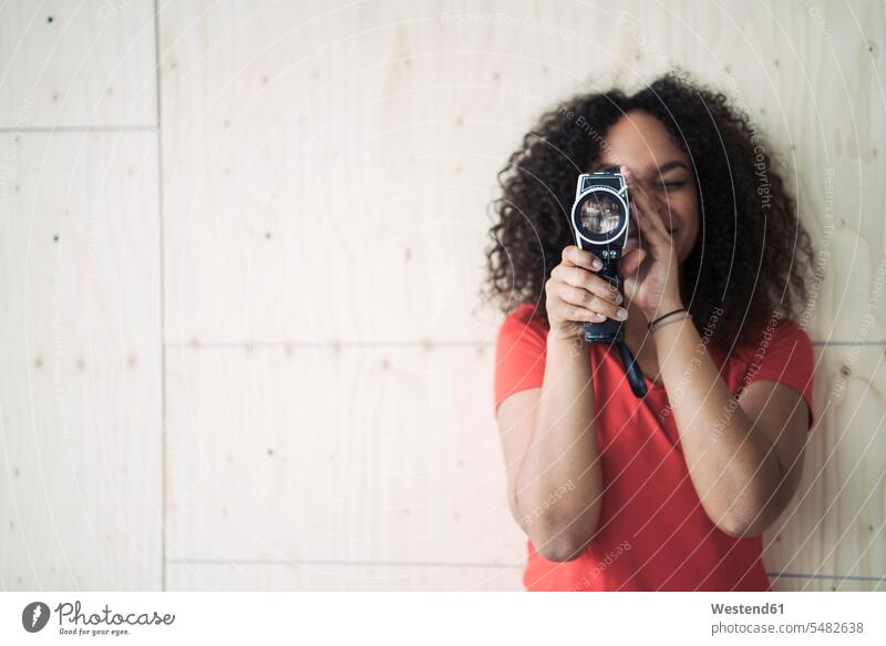 Junge Frau benutzt Kamera der alten Schule altmodisch Filmkamera Filmkameras analog filmen jung weiblich Frauen Erwachsener erwachsen Mensch Menschen Leute