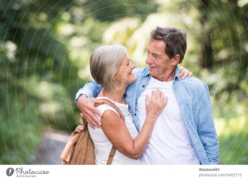 Glückliches älteres Ehepaar von Angesicht zu Angesicht im Wald ansehen Paar Pärchen Paare Partnerschaft Forst Wälder schauen sehend Mensch Menschen Leute People