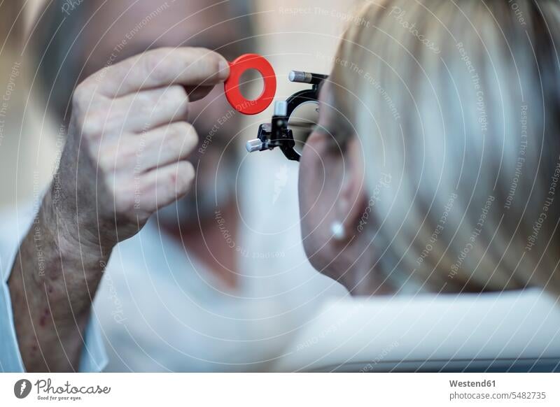 Optometrist, der den Testrahmen für den Patienten einstellt Sehtest Augenuntersuchung Augenuntersuchungen Sehtests Augenoptiker Optiker Brille Brillen testen