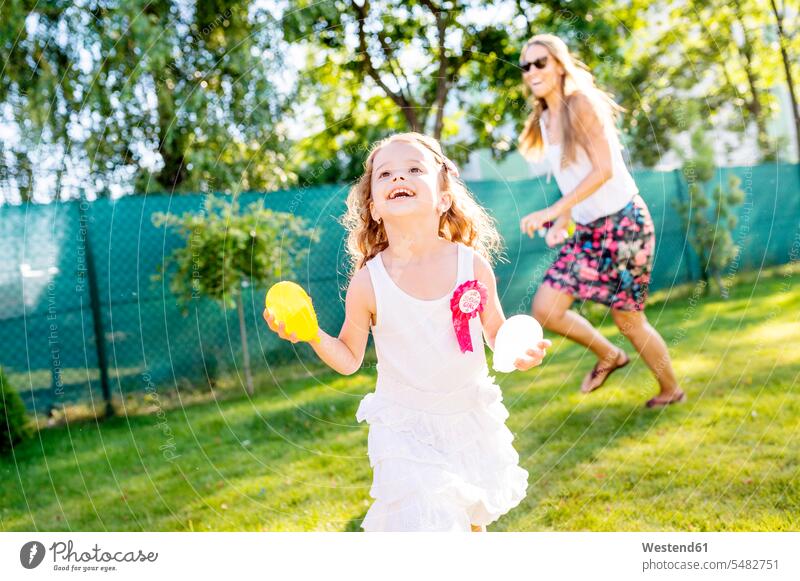 Kleines Mädchen amüsiert sich mit Wasserbomben im Garten Ballon Luftballons Ballons weiblich Kind Kinder Kids Mensch Menschen Leute People Personen Gärten