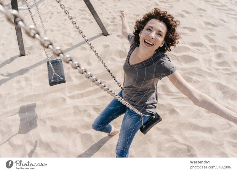 Glückliche Frau auf einer Schaukel Schaukeln lachen weiblich Frauen Strand Beach Straende Strände Beaches positiv Emotion Gefühl Empfindung Emotionen Gefühle