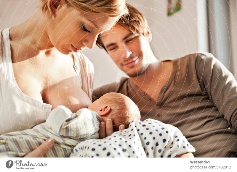 Mutter stillt ihr Neugeborenes unter Beobachtung des Vaters Mami Mutti Mütter Mama stillen Kind Babies Babys Kinder Eltern Familie Familien Mensch Menschen