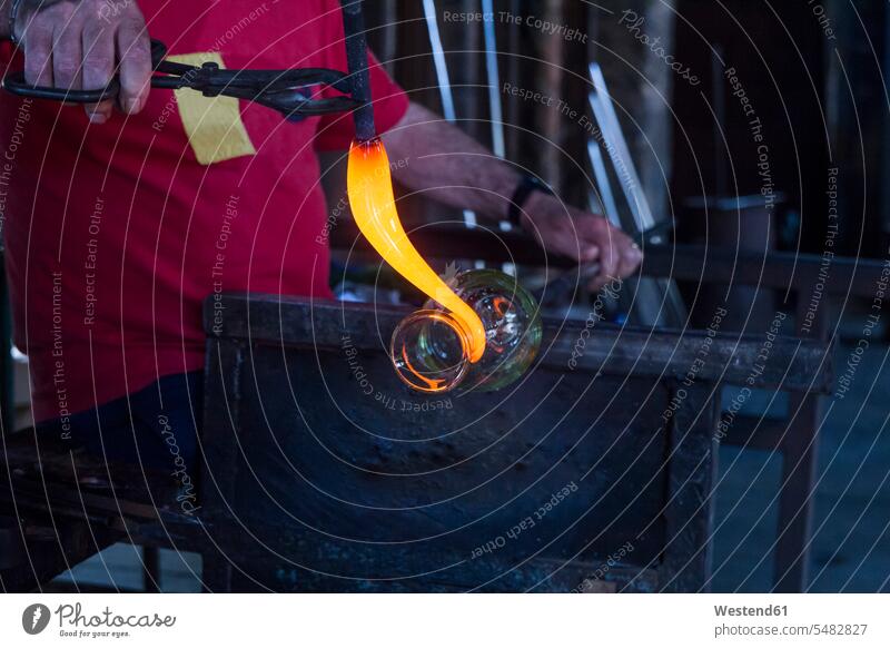 Mann arbeitet mit geschmolzenem Glas in einer Glasfabrik Glasbläser Glasblaeser formen arbeiten Arbeit Job gläsern Glasbläserei Glasbläsereien Glasblaeserei