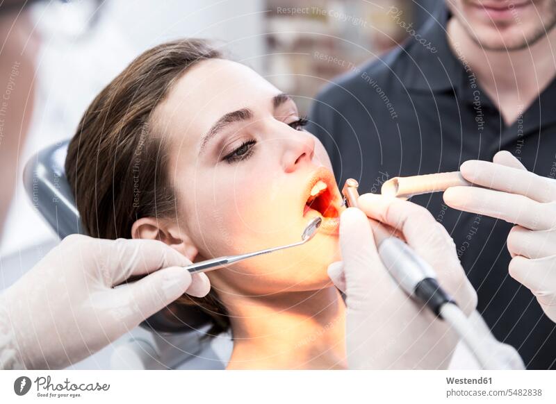 Junge Frau beim behandelnden Zahnarzt Zahnpflege Mundpflege Mundhygiene Zahnärzte Dentist Zahnaerzte Dentisten Arztpraxis Arztpraxen Praxis Behandlung