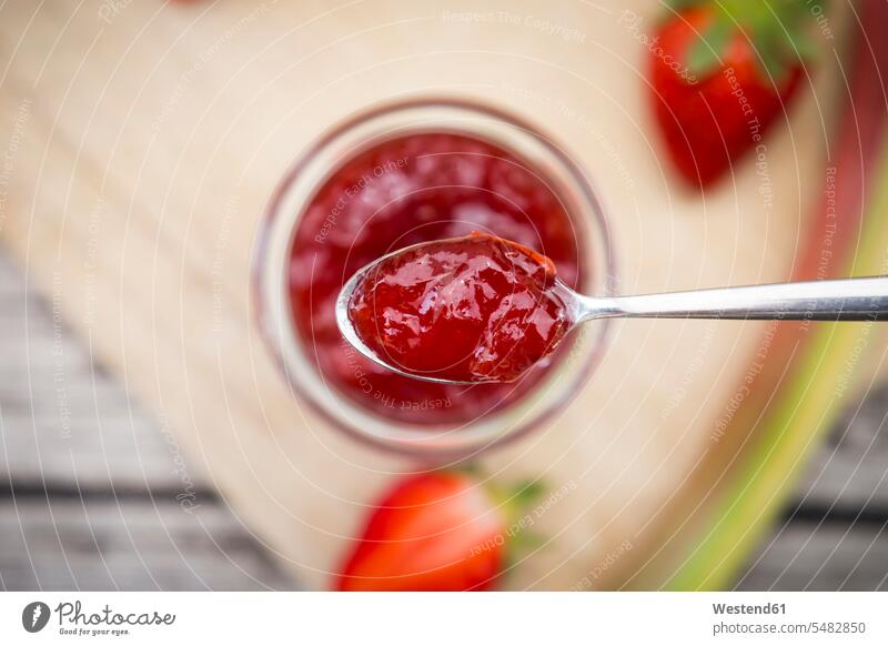 Glas hausgemachte Erdbeer-Rhabarber-Marmelade Erdbeere Erdbeeren Fragaria Konfitüre Konfituere hölzern Holzbrett Holzplatten Holzbretter Einweckglas Vorratsglas