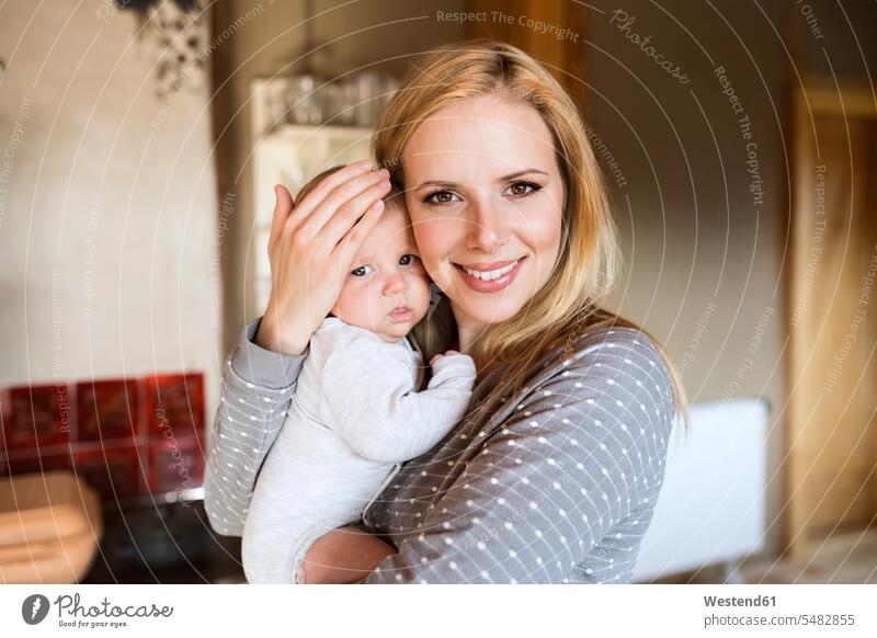 Porträt einer lächelnden Mutter, die ihr Baby zu Hause hält Babies Babys Säuglinge Kind Kinder Mami Mutti Mütter Mama Mensch Menschen Leute People Personen