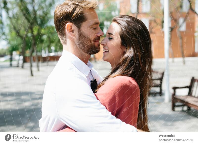 Glückliches Paar, das sich auf der Straße küsst und umarmt küssen Küsse Kuss Pärchen Paare Partnerschaft umarmen Umarmung Umarmungen Arm umlegen romantisch